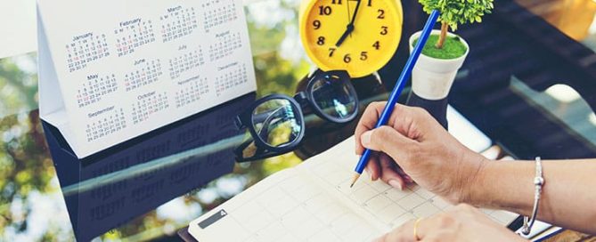 Woman marks down notes in her calendar notebook.