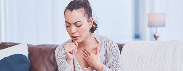 Female homeowner coughs because of common indoor air pollutants circulating.